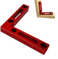 Aluminium alloy right angle woodworking positioning block on a workbench.