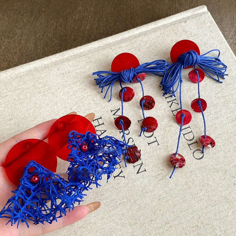 Geometric-shaped cloth earrings in silver needle and blue resin flower colours.