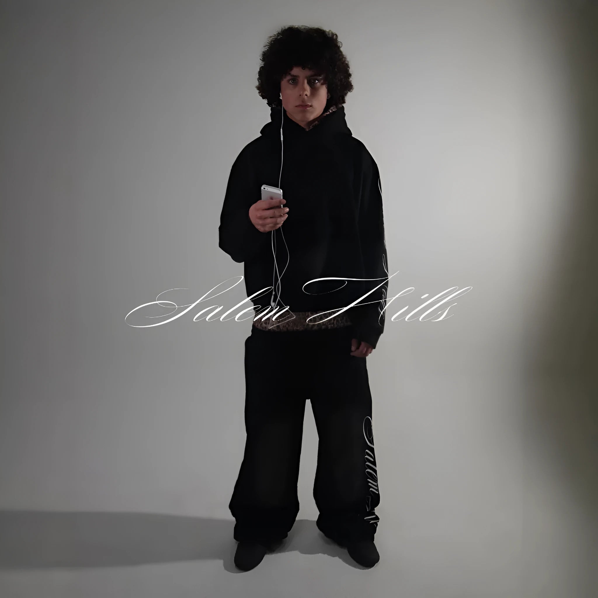 Men's black and white punk print pullover hoodie and pants tracksuit set on a hanger.