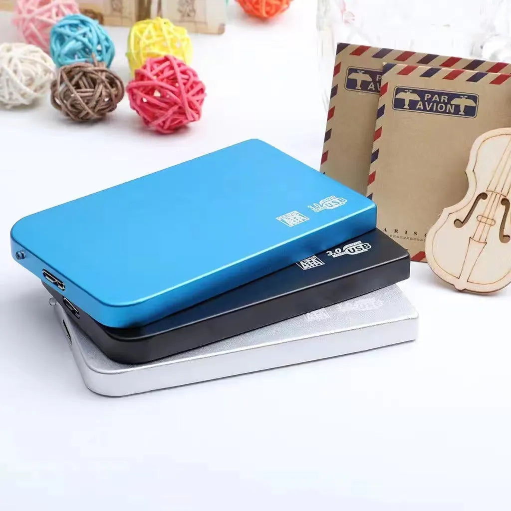 Silver USB 3.0 solid state mobile hard disk with data cable on a desk.