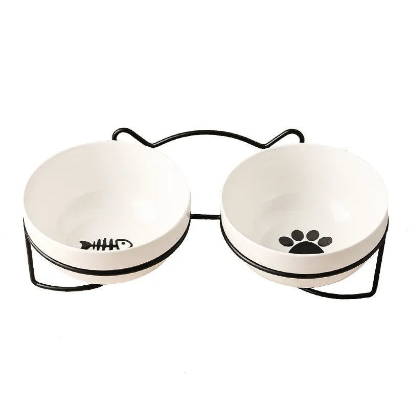 White ceramic cat bowl with cat footprint design on a black iron stand with cat ears.