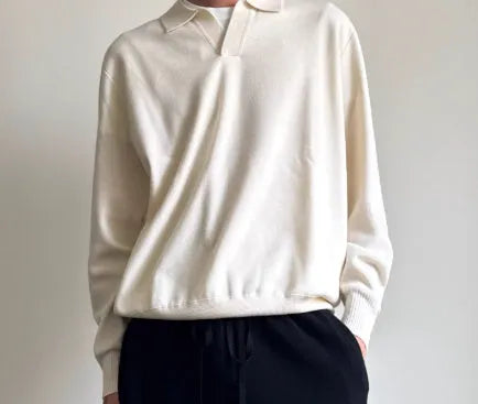 Man wearing a milky white pure wool polo sweater with a lapel collar, showcasing its loose fit.
