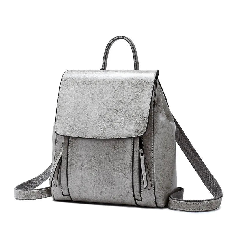 Large genuine cowhide leather women's backpack in black, shown with open cover to reveal internal zipper pockets and phone sleeve.
