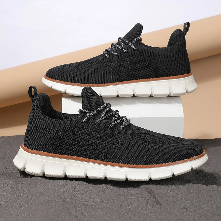 Men's grey and black low-top casual sneakers with woven mesh fabric upper and round toe.