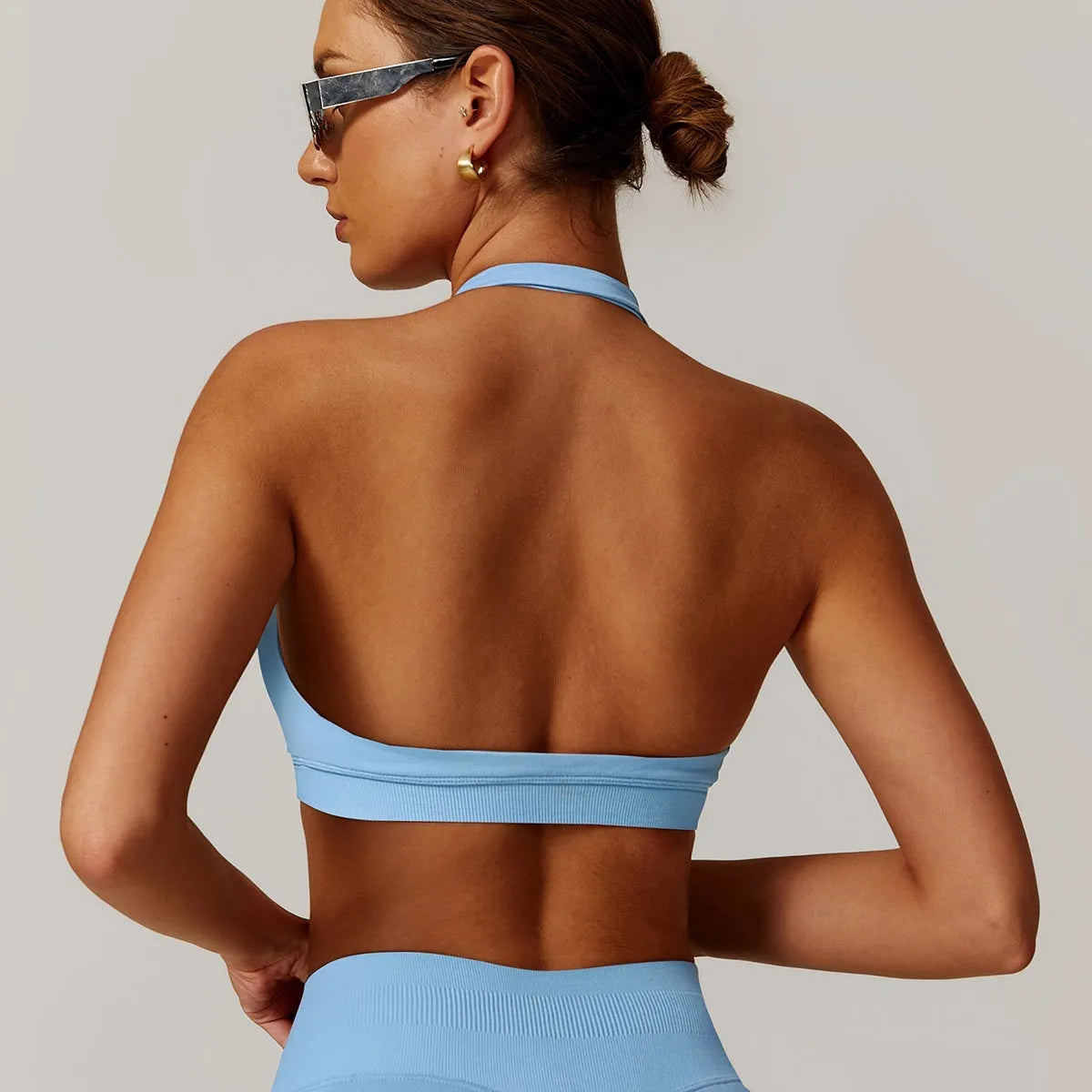 Women's black halter-style yoga sports bra with medium support and built-in chest pads.