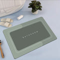 Diatom mud absorbent bathroom floor mat in blue rectangular shape on tiled floor