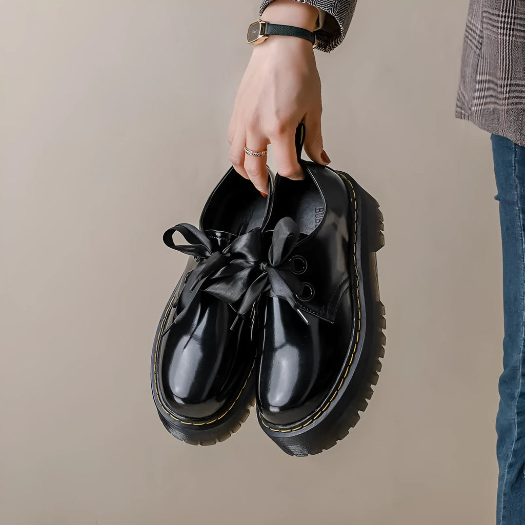 Women's black thick soled leather shoes with cross strap and ribbon lacing closure