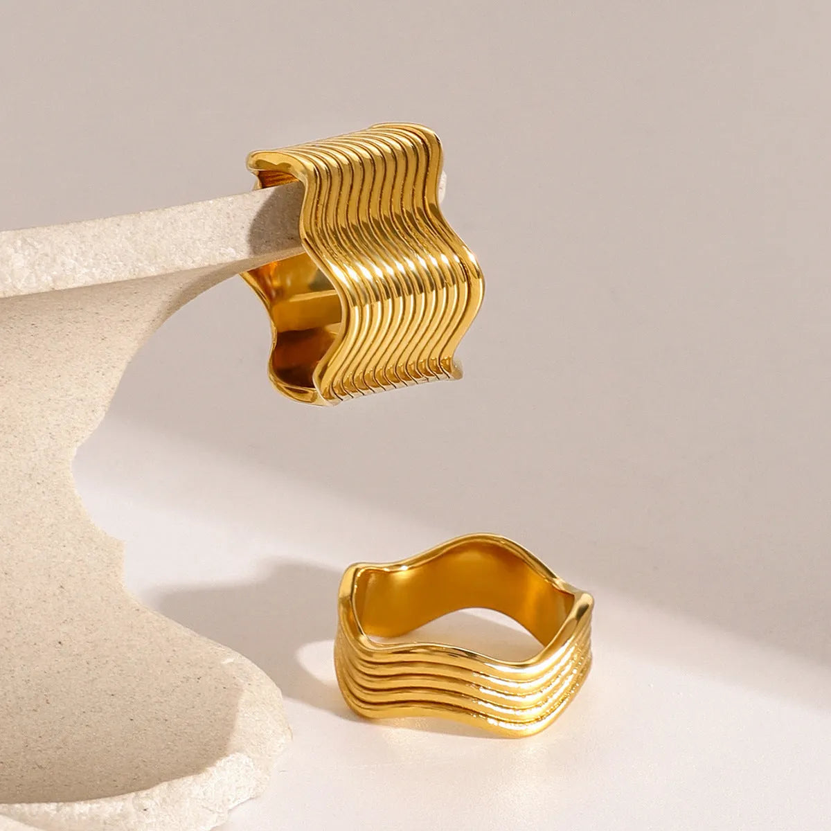 Stainless steel geometric wave ring for women in silver or gold finish.