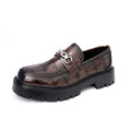Men's black crocodile pattern loafers with a flat platform sole on a plain background.