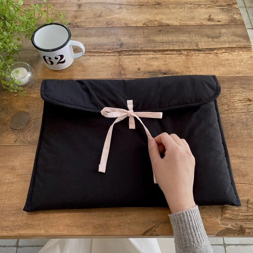 Women's black and white quilted nylon computer bag with striped pattern and bow detail
