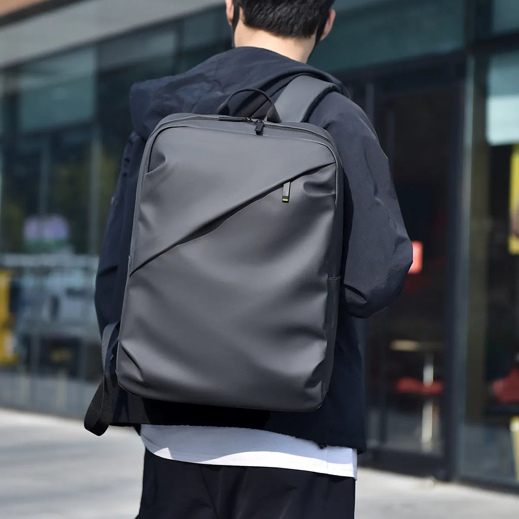 Large waterproof backpack in black, blue, or grey with PU leather construction and computer compartment