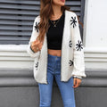 Beige Jacquard floral pattern knitted coat on a hanger, showing loose cardigan style and regular sleeves.