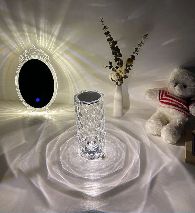 Creative acrylic crystal rose LED table lamp with adjustable three-colour lighting on a wooden surface.