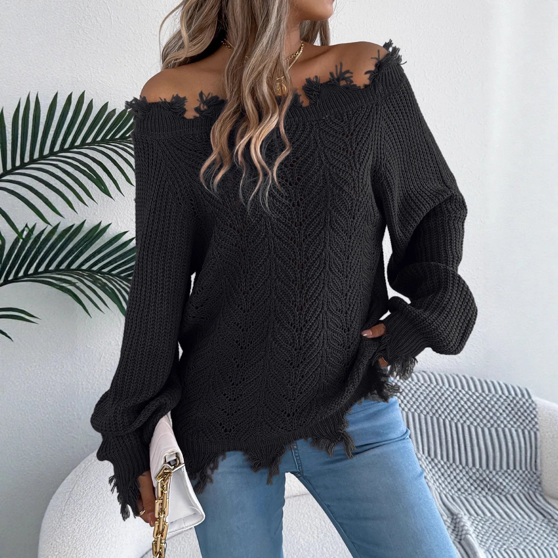 Women's white hollow-out off-the-shoulder long sleeve pullover sweater on a hanger.