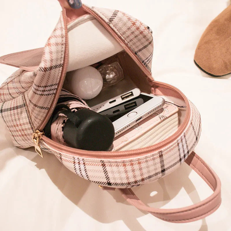 A one shoulder diagonal phone bag made from black PU fabric, shown being worn crossbody.