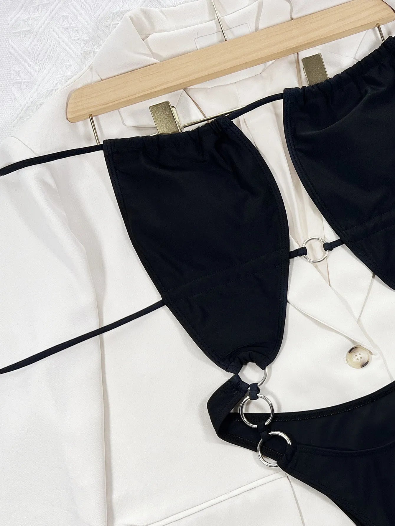 Black sleeveless one-piece swimsuit for women on a hanger
