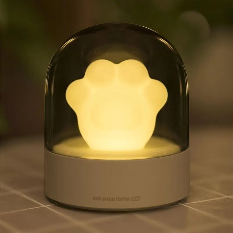 Grey cat paw shaped USB rechargeable night light with musical features on wooden desk