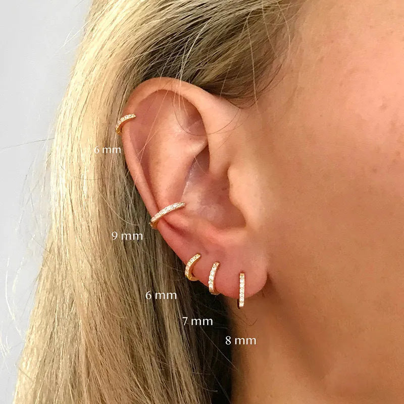 A pair of perforated circular stud earrings with zircon detailing in gold, rose gold, or silver colour.
