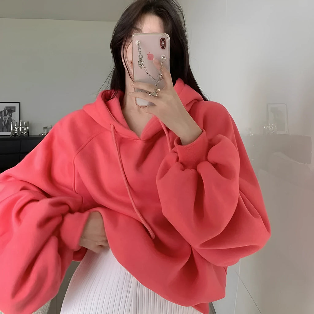 Watermelon red women's sleeveless silk hooded sweater on a hanger showing loose fit and hood detail.