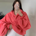 Watermelon red women's sleeveless silk hooded sweater on a hanger showing loose fit and hood detail.