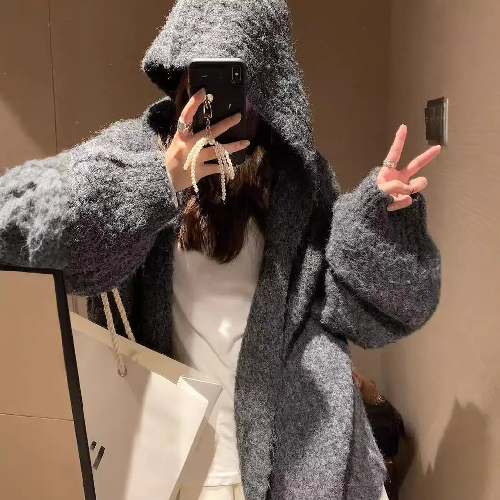 Women's loose grey hooded cardigan with a thick knit and oversized fit on a hanger.
