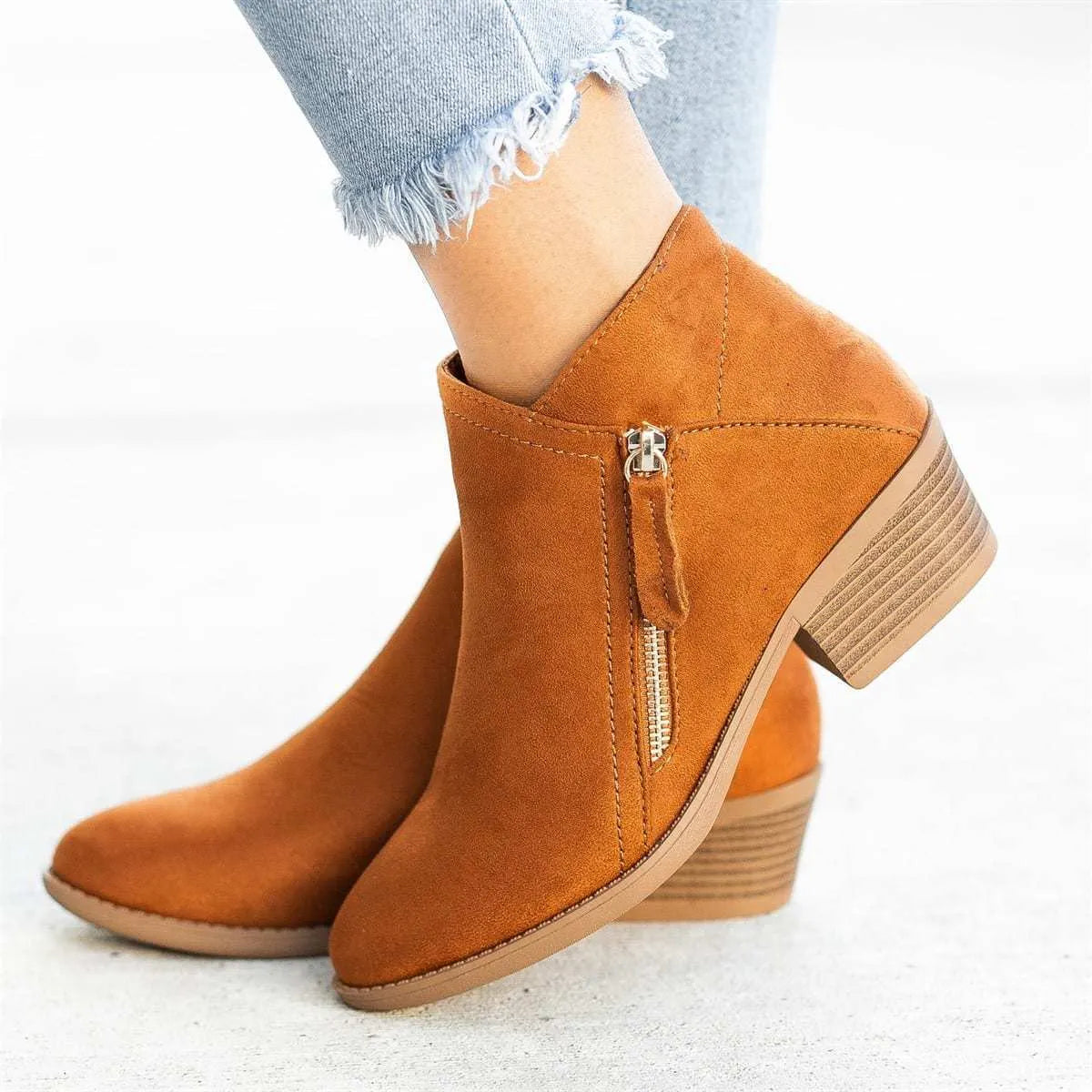 Women's beige suede ankle boot with side zip, lace-up front, and chunky composite sole.