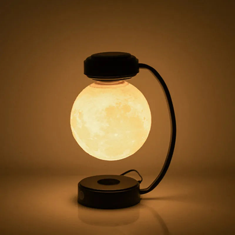 3D LED moon night light with magnetic levitation, floating ball, iron base, black finish on a desk