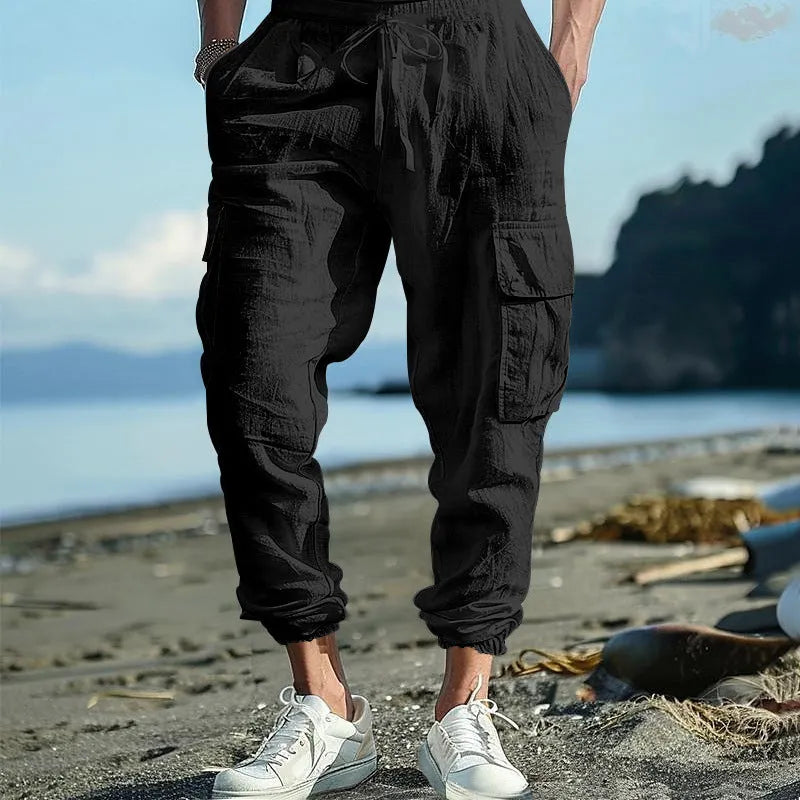 Men's loose-fit linen casual trousers with ankle ties and multiple pockets in a solid colour.