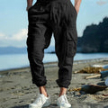 Men's loose-fit linen casual trousers with ankle ties and multiple pockets in a solid colour.