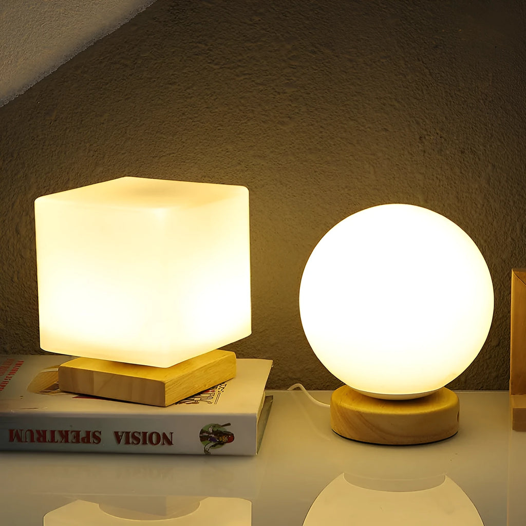 White Nordic solid wood USB table lamp with touch dimming in cube shape on a wooden table.