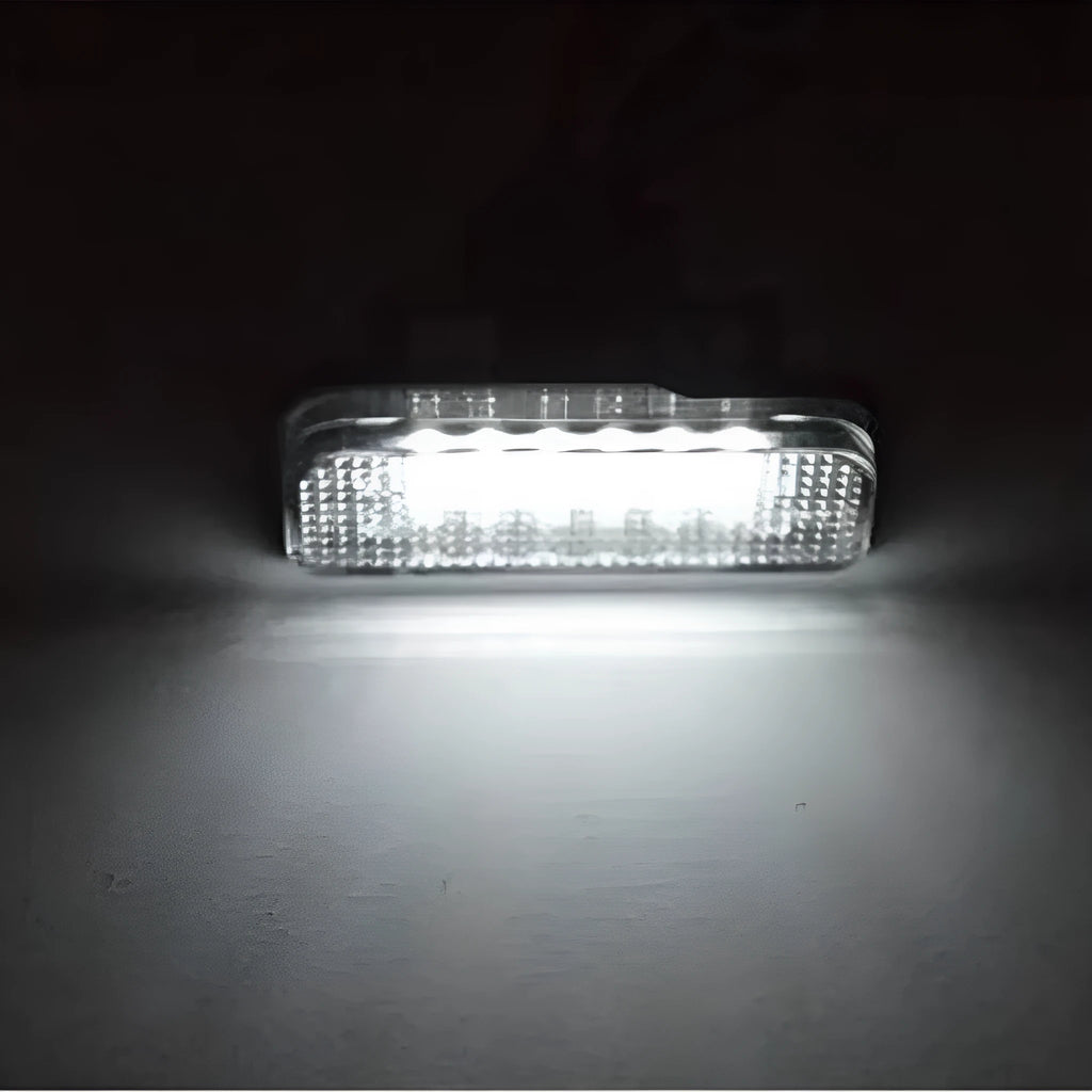 Mercedes Benz LED licence plate light unit with 18 white LEDs, shown next to a ruler for scale.