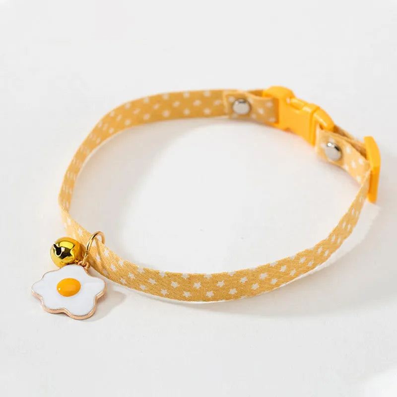 Adjustable green cat collar with a metal bell pendant and a matching bow tie decoration.