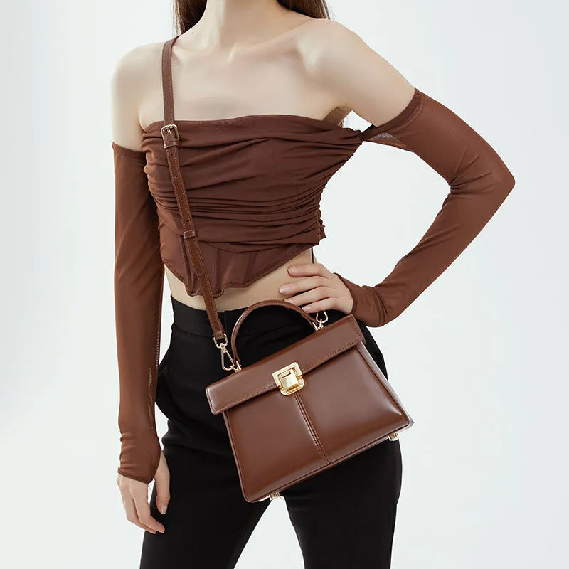 Black genuine leather women's shoulder bag with a vachette clasp, shown open to reveal a zippered hidden pocket.