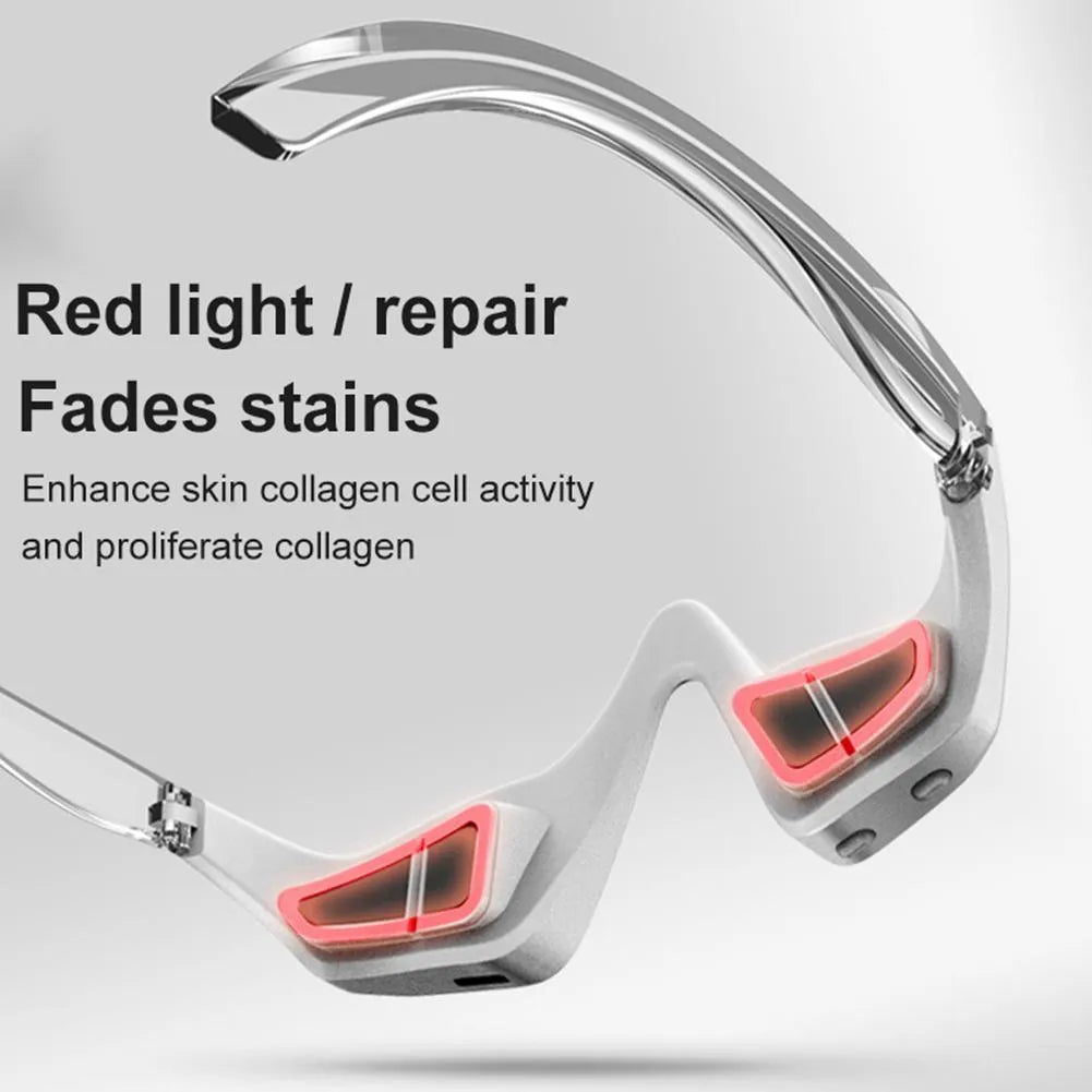 Pink and white 3D micro-current eye massager shaped like glasses on a grey background.