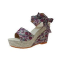 Women's pink floral peep toe wedge sandals with an ankle strap buckle on a rubber sole.