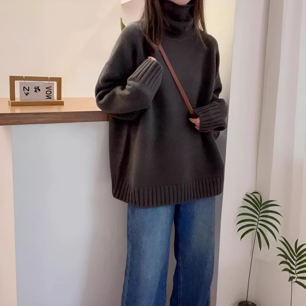 A woman wearing a loose red turtleneck sweater with a thick, curling pile collar.