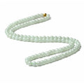 Adjustable necklace with a round white and green jade bead on a silver chain.