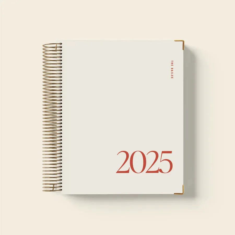 Cherry red wire-bound coil notebook with daily schedule pages open flat