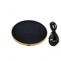 Black USB-powered beverage warming coaster with tempered glass top on a wooden desk