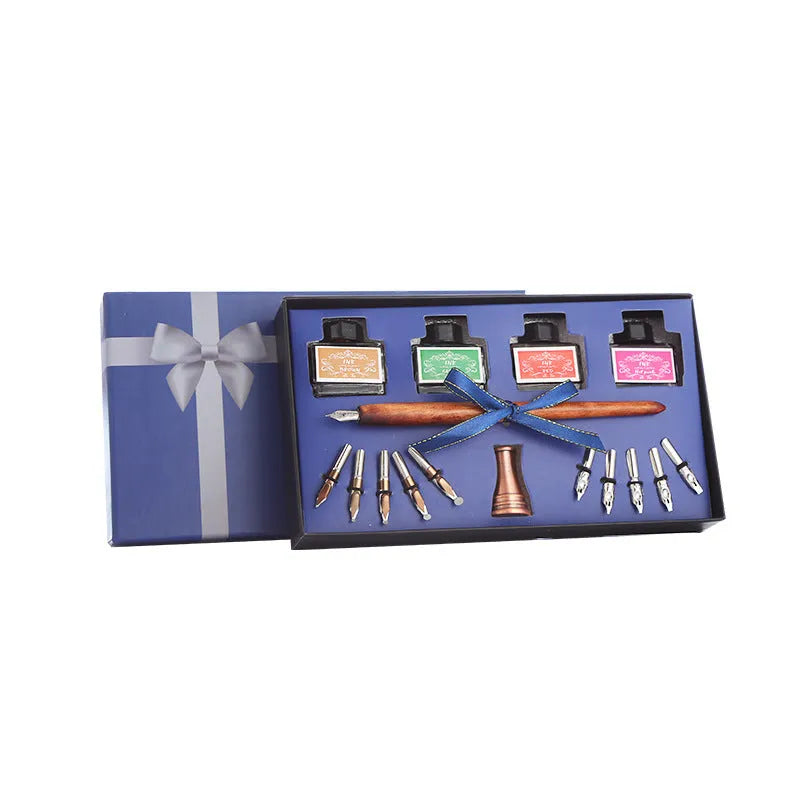 Wooden dip pen, coloured ink bottles, and nibs arranged inside a wooden gift box for calligraphy.