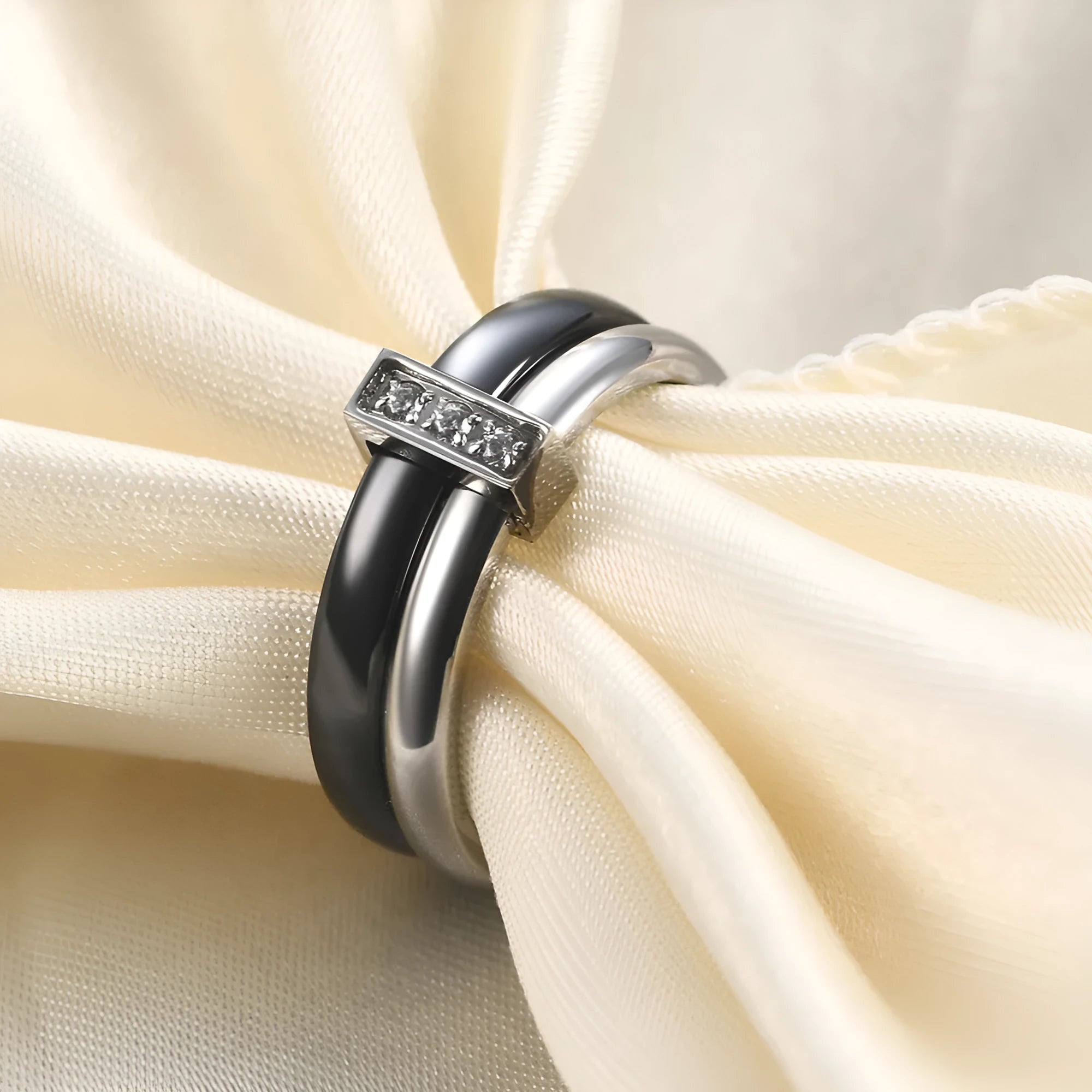 Glossy black ceramic women's ring with geometric shape and inlaid zirconium details on a finger.