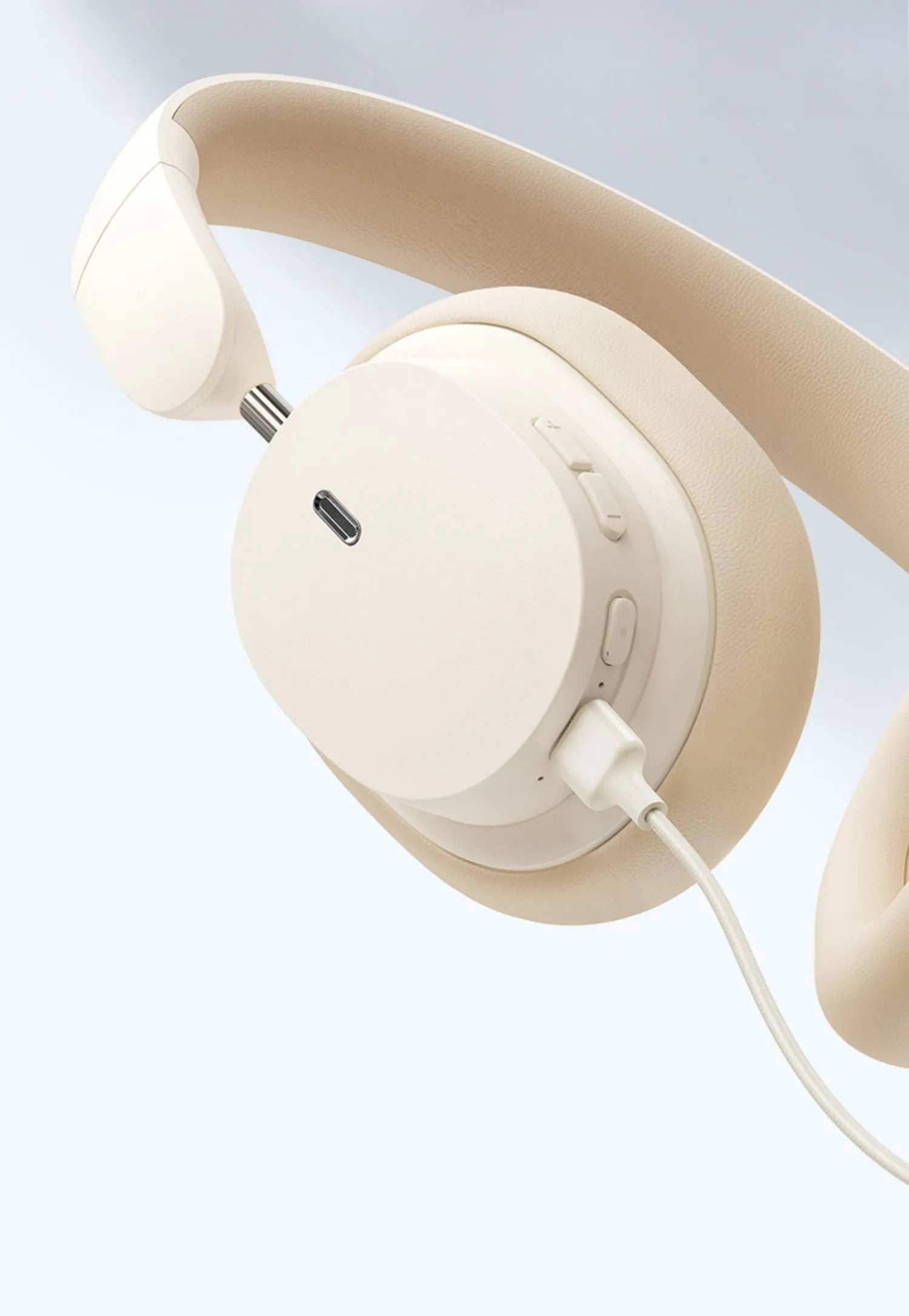 Beige and grey Bluetooth over-ear headphones with head-mounted design showing earcups and adjustable headband