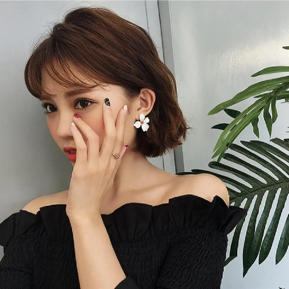 Women's floral stud earrings in white or pink electroplated alloy with flower shape design