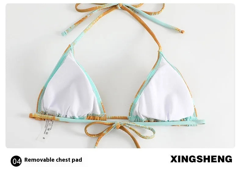 Green-brown women's long-sleeved tulle bikini top with matching swim pants and skirt laid flat.