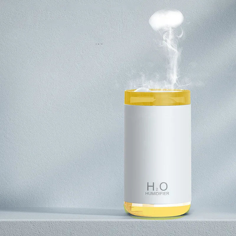 White portable USB humidifier with jellyfish mist spray and warm night light on wooden surface