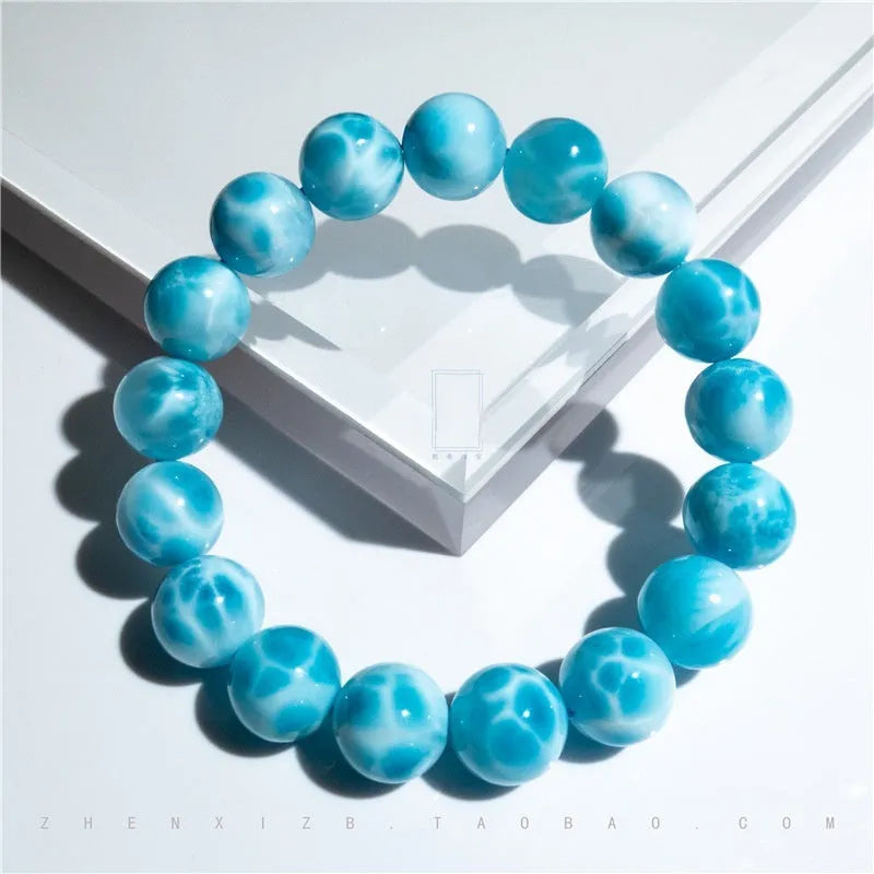 Blue Bodhi bead bracelet with white pearl accents on a plain background.
