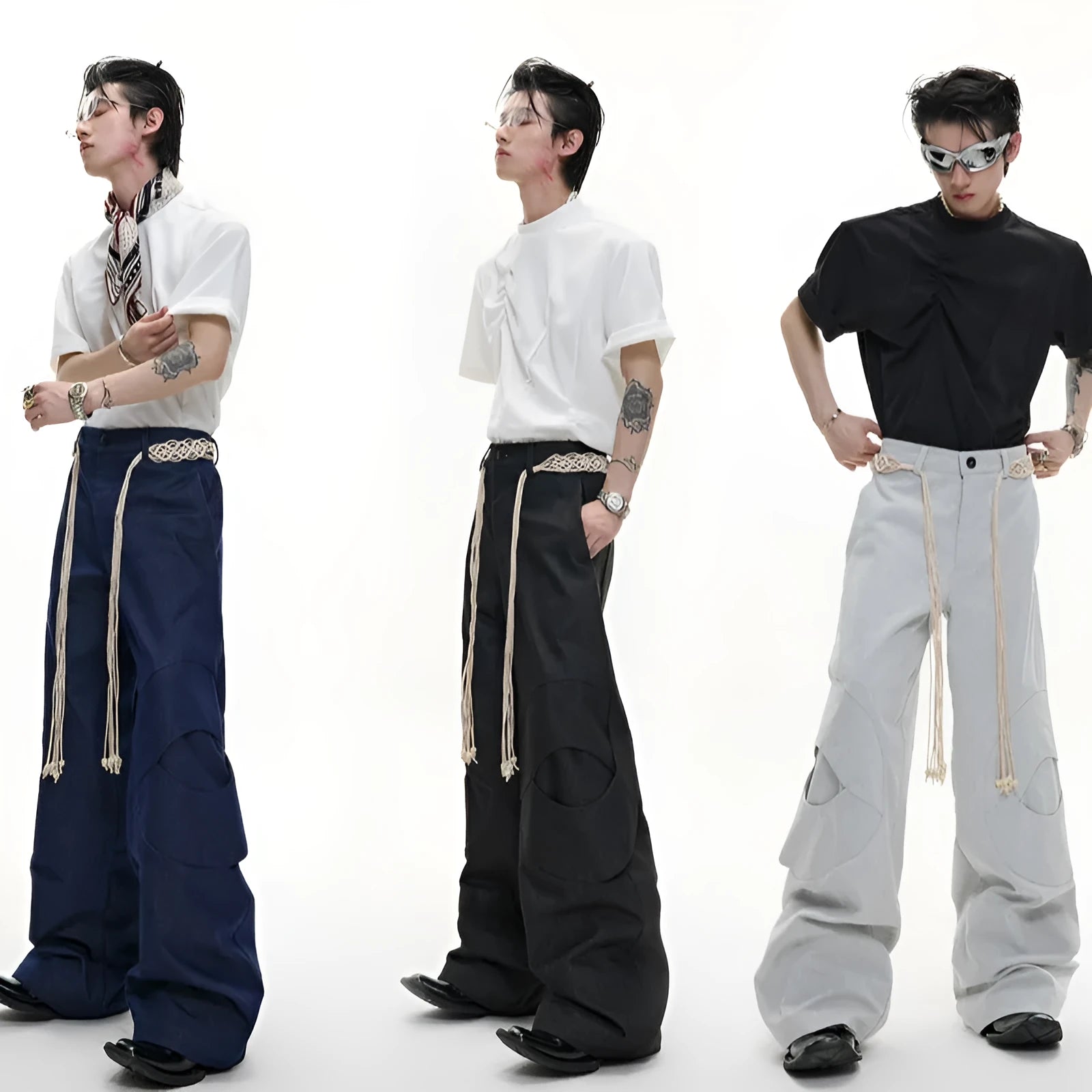 Men's dark blue straight-leg jeans with heavy 3D cutting, belt stitching, and tassel details on a loose fit.