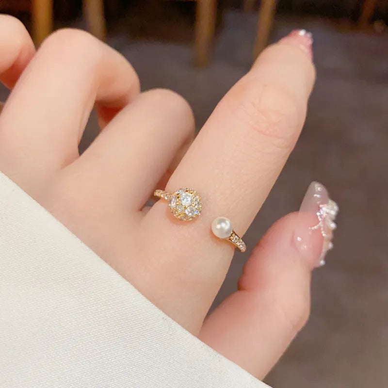 Minimalist open-end ring with round zircon stone on a geometric band in gold tone.