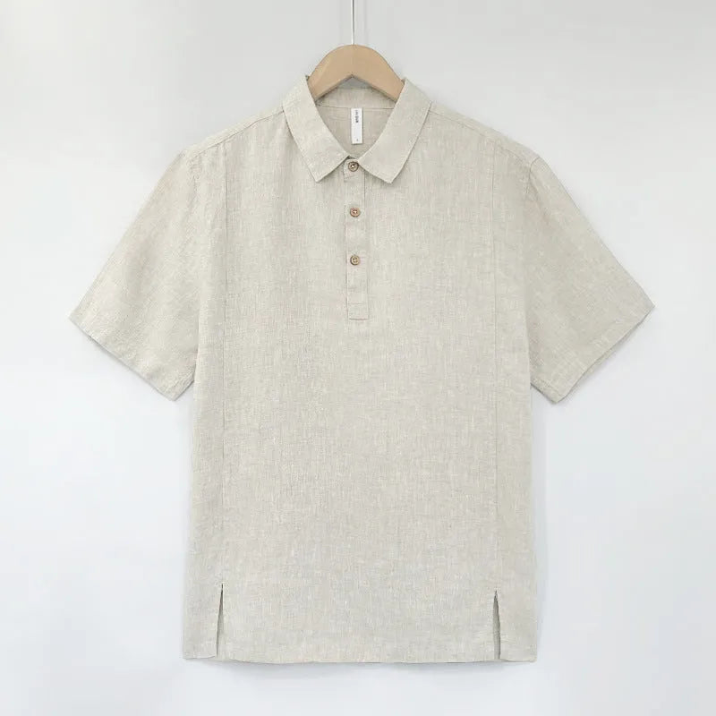 A man's loose-fit linen short-sleeve top in grey green with a V-neck and thin lapels, laid flat.