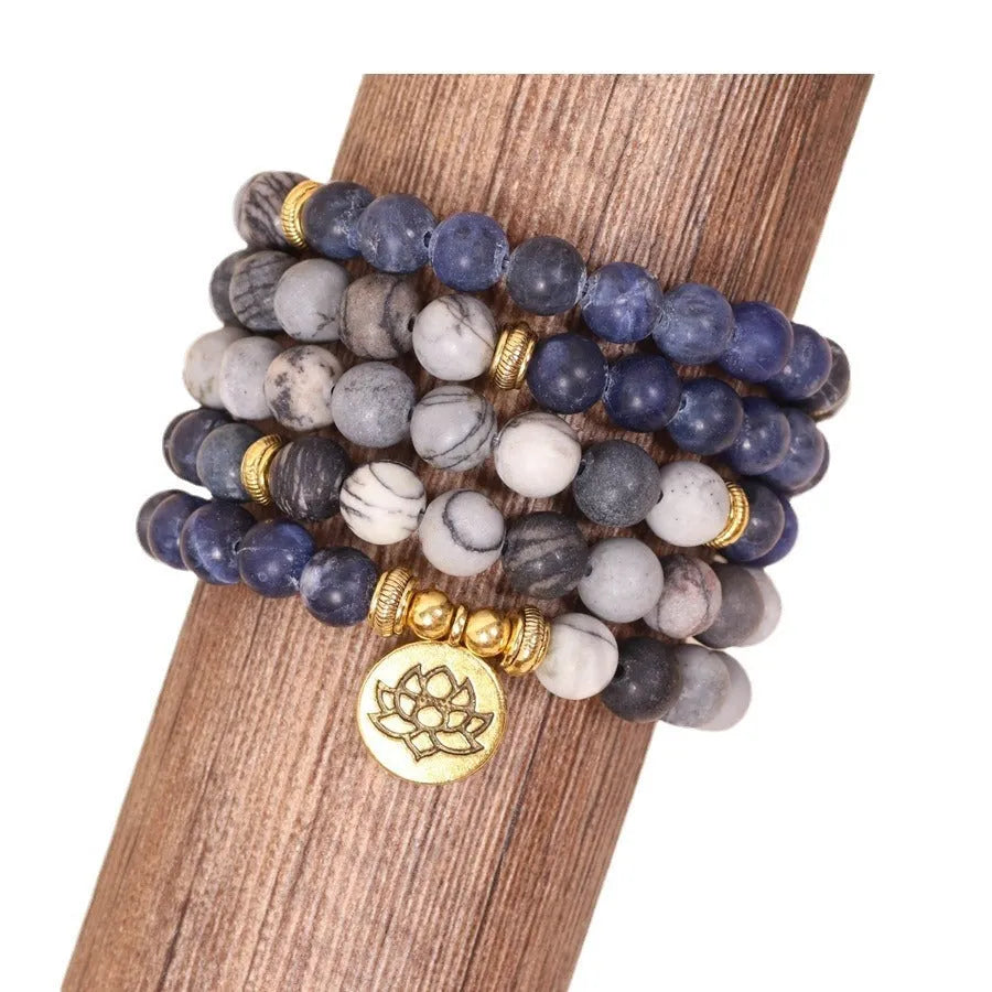 Close-up of a blue patterned network stone bead multi-layer alloy bracelet on a wrist.